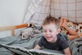 Preschooler boy reading book laying in his bed. spending time at home. Lifestyle family concept Royalty Free Stock Photo