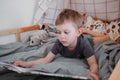 Preschooler boy reading book laying in his bed. spending time at home. Lifestyle family concept Royalty Free Stock Photo