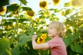 Preschooler boy walking in field of sunflowers. Child playing with big flower and having fun. Kid exploring nature. Baby having Royalty Free Stock Photo