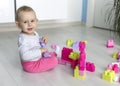 Preschooler child playing with colorful toy blocks