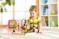 Preschooler child playing with colorful toy. Kid playing with educational wooden toy at kindergarten or daycare center. Toddler in