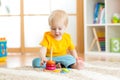 Preschooler child playing with colorful toy. Kid playing with educational wooden toy at kindergarten or daycare center. Toddler in