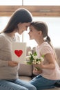 Preschooler child present flowers and postcard to young mom Royalty Free Stock Photo