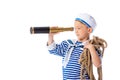 Preschooler child in sailor costume looking in spyglass and holding rope isolated on white