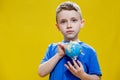 A preschooler discovers the world, a cute boy holds a small globe in his hands and looks at it, learns something new Royalty Free Stock Photo