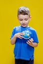 A preschooler discovers the world, a cute boy holds a small globe in his hands and looks at it, learns something new Royalty Free Stock Photo