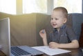 Preschooler is engaged in home schooling. The boy sits at a table, writes, draws and learns online on the Internet. Quarantine Royalty Free Stock Photo