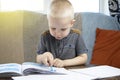 Preschooler is engaged in home schooling. The boy sits at a table, writes, draws and learns online on the Internet. Quarantine Royalty Free Stock Photo