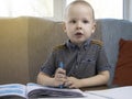 Preschooler is engaged in home schooling. The boy sits at a table, writes, draws and learns online on the Internet. Quarantine Royalty Free Stock Photo