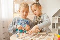 Preschoolers play and learn English letters using wooden alphabet. Royalty Free Stock Photo