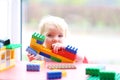 Preschooler girl building from plastic bricks