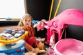 Preschooler girl child in day care center playing with dolls toys