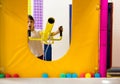 A preschooler girl shoots yellow foam with soft foam balls. activities for children in the playground in the room