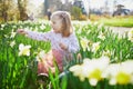 Preschooler girl sitting on the grass with yellow narcissi Royalty Free Stock Photo