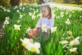 Preschooler girl sitting on the grass with yellow narcissi Royalty Free Stock Photo