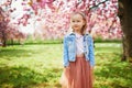 preschooler girl in tutu skirt enjoying nice spring day in cherry blossom garden