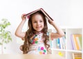 Preschooler kid girl with book over her head Royalty Free Stock Photo