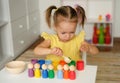 Preschooler kid learns colors and shapes by playing a wooden toy