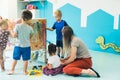 preschoolers painting on the cellophane with their teacher in kindergarten, beautiful painted walls in the background Royalty Free Stock Photo