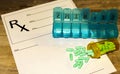 Prescription bottle with green pills, pill minder on RX form