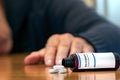 Prescription bottle with Oxycodone tablets on a table over a man wih blur hand Royalty Free Stock Photo