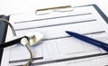 Prescription form lying on table with stethoscope and blue pen. Royalty Free Stock Photo