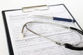 Prescription form lying on table with stethoscope and silver pen. Royalty Free Stock Photo