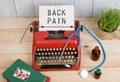 Prescription medicine or medical diagnosis - doctor workplace with stethoscope, pills, typewriter with text Back Pain Royalty Free Stock Photo