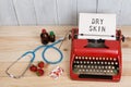 Prescription medicine or medical diagnosis - doctor workplace with stethoscope, pills, typewriter with text Dry Skin, strawberries Royalty Free Stock Photo