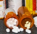 Prescription pill bottles on a black counter with pills spilling out Royalty Free Stock Photo