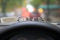 Prescripton glasses on the dashboard of a car with bokeh background