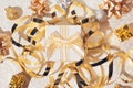 Present box, balls, golden streamer and decorative bows on white glittering background