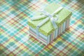 Present box on colorful checked tablecloth holidays concept