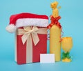 Present box covered by santa claus hat and wrapped wine with blank card for text Royalty Free Stock Photo