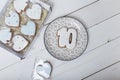 Present box and gingerbread cookies. Hearts and number 10 shapes. Sweets on white wooden background.