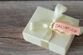 Present box with a ribbon and a text note with handwritten word \