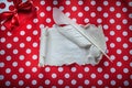 Present box vintage paper roll feather on polka-dot red tableclo