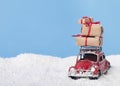 Present boxes on red toy car Volkswagen Beetle on background with snow Royalty Free Stock Photo