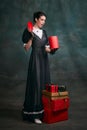 With present boxes. Young beautiful woman in image of Anna Karenina in retro black dress posing over dark vintage Royalty Free Stock Photo