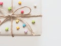 A present or gift box wrapped by rough brown recycled paper and tied with brown hemp rope as ribbon with multi color star isolated Royalty Free Stock Photo