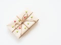 A present or gift box wrapped by rough brown recycled paper and tied with brown hemp rope as ribbon with red and green star isola Royalty Free Stock Photo