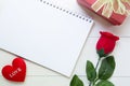 Present gift with red rose flower and notebook and heart shape with copy space on wooden table Royalty Free Stock Photo