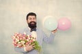 Present for spouse. Guy with air balloons. Birthday party. Bearded man hipster with flower bouquet. Womens day. Bearded