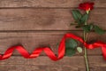 Present for St. Valentines Day - Red rose with ribbon on dark wooden background copyspace Royalty Free Stock Photo