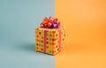 Present wrapped in yellow paper with colorful polka dot pattern. Pink ribbon and colorful bow on top of gift box. Royalty Free Stock Photo