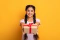 Happy indian woman holding present box and giving to camera Royalty Free Stock Photo