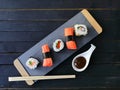 Presentation board with sushi with rice and salmon and rolls wit