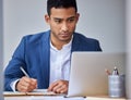 This presentation could make or break the business. a young businessman taking notes while using his laptop. Royalty Free Stock Photo