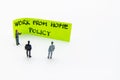 Presentation meeting with miniature figurines posed as business people standing in front of post-it note with Work From Home Royalty Free Stock Photo