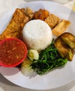 a presentation of traditional Indonesian food in the form of fresh rice with very spicy chili sauce